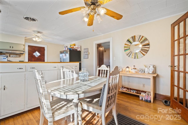 dining area featuring crown molding and light hardwood / wood-style floors