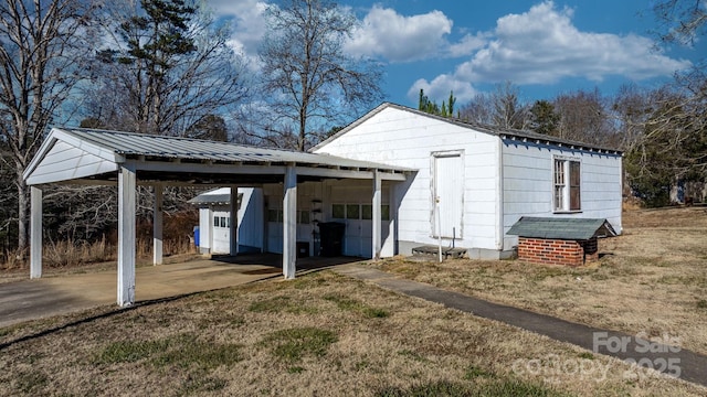 view of outbuilding featuring a carport and a lawn