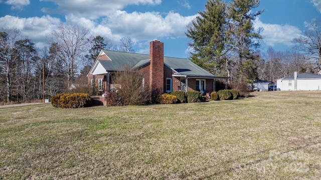 view of side of property with covered porch and a lawn