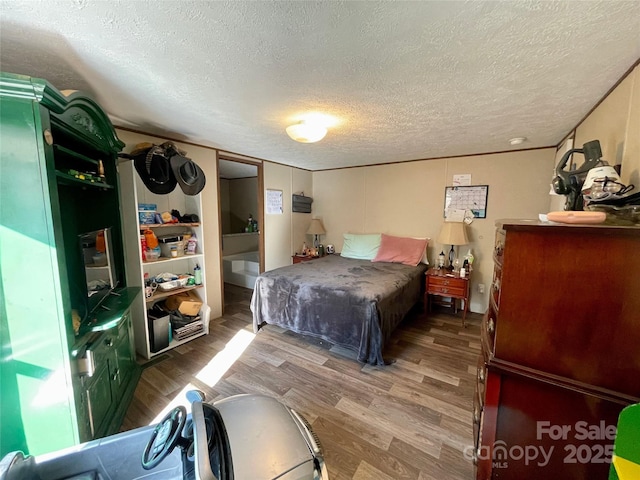 bedroom featuring hardwood / wood-style flooring and a textured ceiling