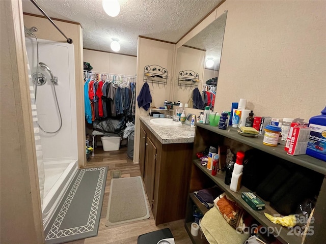 bathroom with vanity, hardwood / wood-style floors, a textured ceiling, and a shower