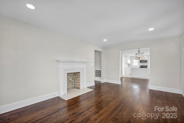 unfurnished living room with wood-type flooring and a chandelier