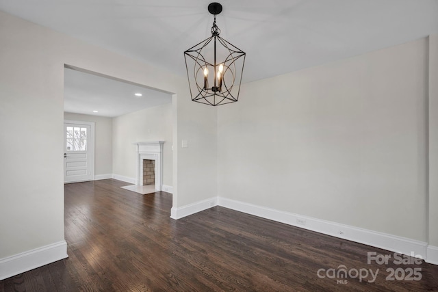 unfurnished dining area featuring dark wood-type flooring and an inviting chandelier