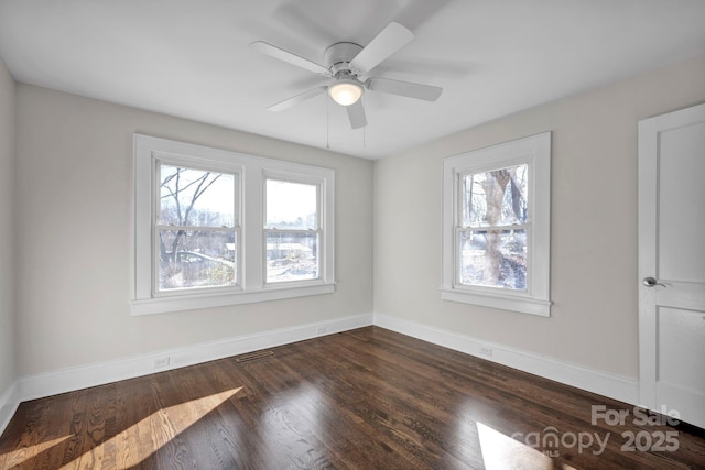 spare room featuring ceiling fan and dark wood-type flooring