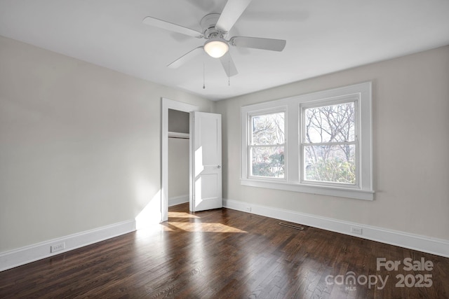 unfurnished bedroom with a closet, ceiling fan, and dark hardwood / wood-style flooring