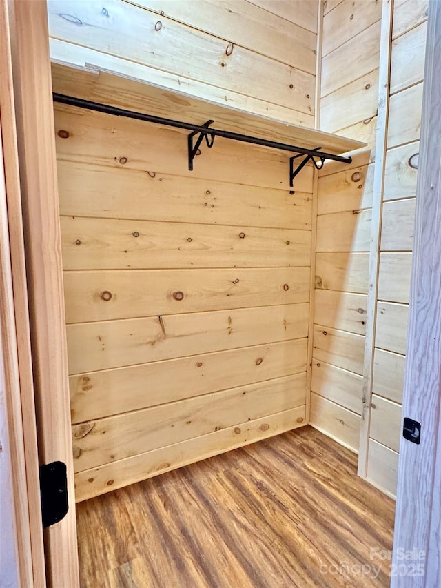 mudroom with wood-type flooring and wooden walls