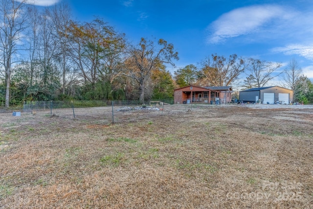 view of yard with a garage and an outbuilding