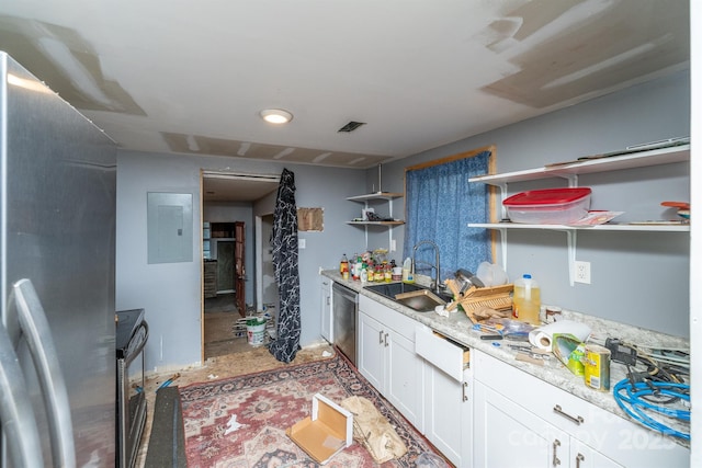 kitchen featuring light stone countertops, appliances with stainless steel finishes, white cabinetry, sink, and electric panel