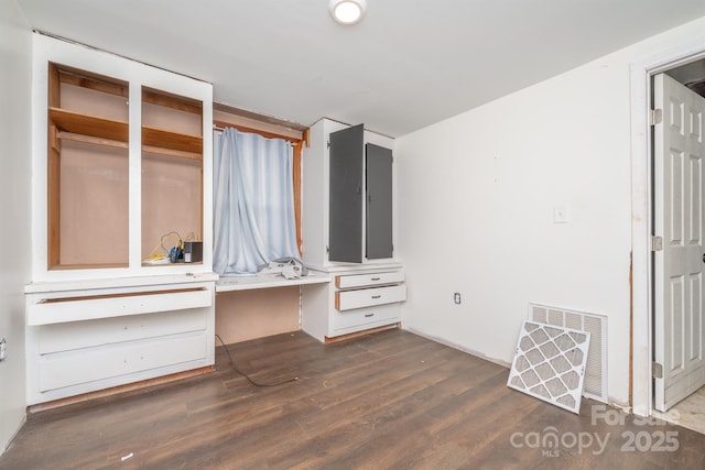 unfurnished bedroom featuring dark hardwood / wood-style floors and built in desk