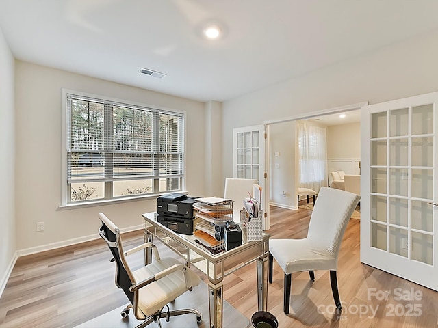 office area with light hardwood / wood-style flooring and french doors