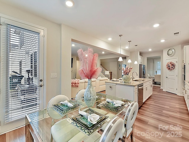 dining room with sink and light wood-type flooring