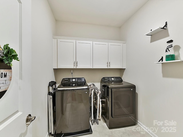 washroom with washing machine and clothes dryer and cabinets