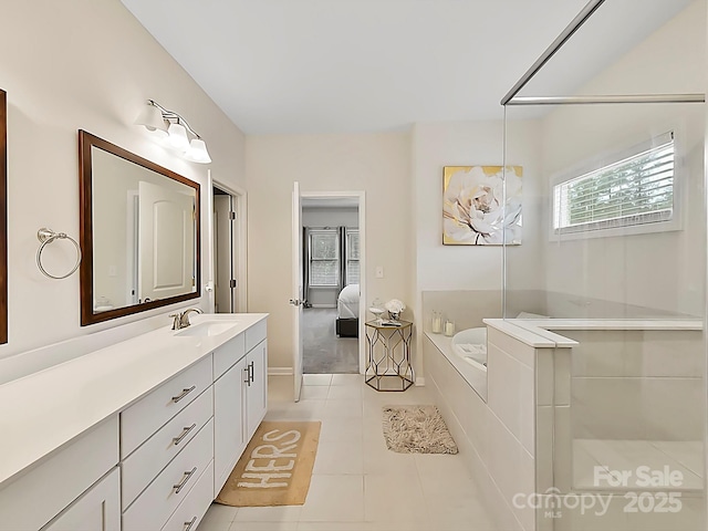 bathroom with vanity, tiled tub, and tile patterned floors