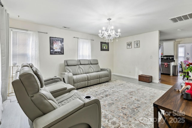 living room with an inviting chandelier and light hardwood / wood-style floors