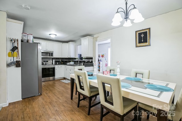 dining area featuring light hardwood / wood-style floors and a notable chandelier