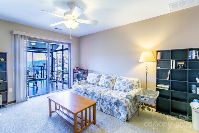 carpeted living room with ceiling fan and visible vents