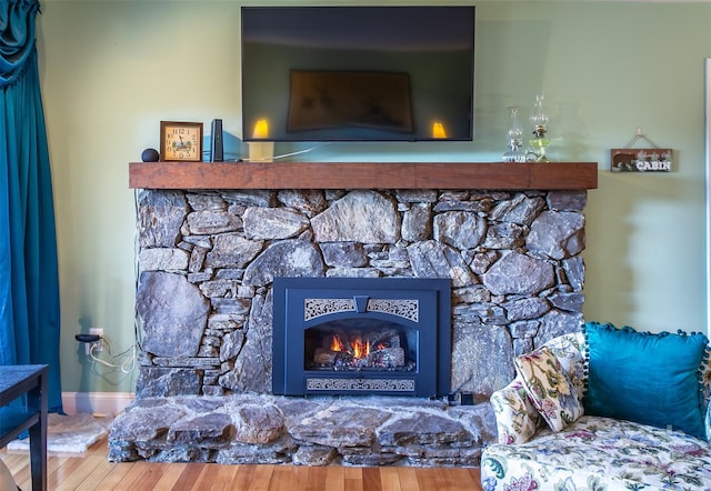 interior details with a fireplace, baseboards, and wood finished floors