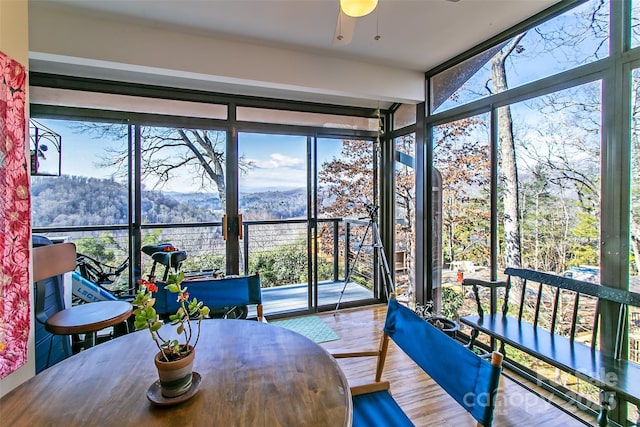 sunroom / solarium featuring a mountain view and a view of trees