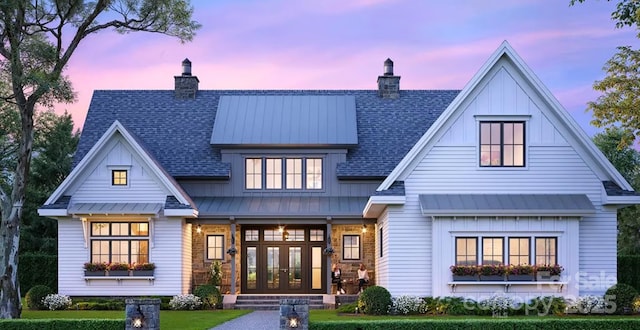 back house at dusk with a yard and french doors