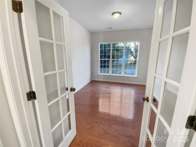 empty room with hardwood / wood-style flooring and french doors