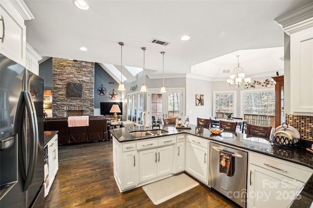 kitchen with refrigerator with ice dispenser, decorative light fixtures, kitchen peninsula, and dishwasher