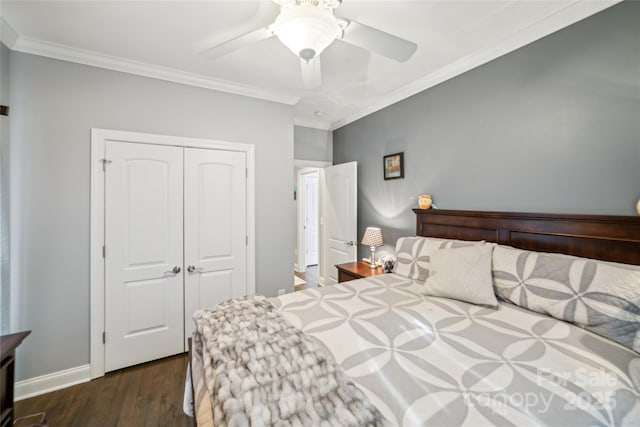 bedroom featuring crown molding, dark wood-type flooring, ceiling fan, and a closet