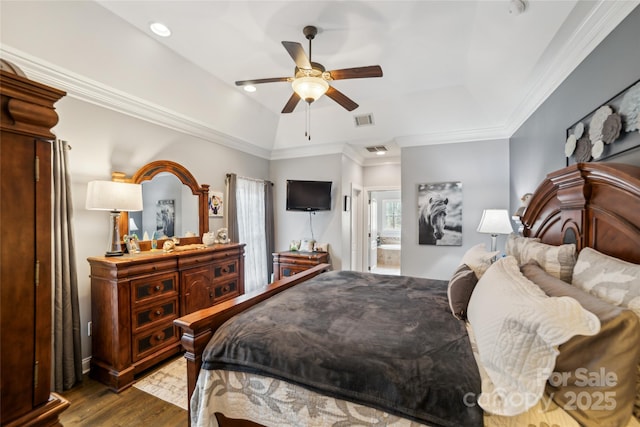 bedroom featuring dark wood-type flooring, ceiling fan, connected bathroom, and a tray ceiling