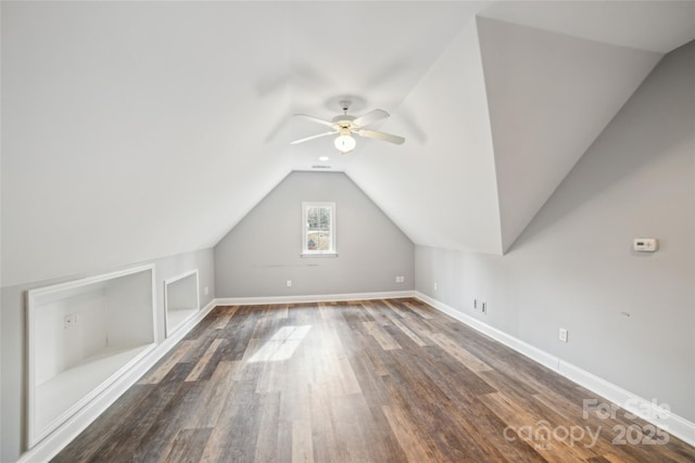 bonus room featuring ceiling fan, dark hardwood / wood-style floors, vaulted ceiling, and built in features