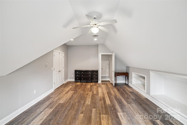 bonus room featuring lofted ceiling, built in features, dark hardwood / wood-style floors, and ceiling fan