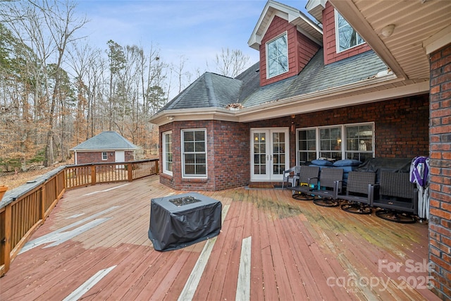 wooden terrace with french doors, area for grilling, and an outdoor fire pit