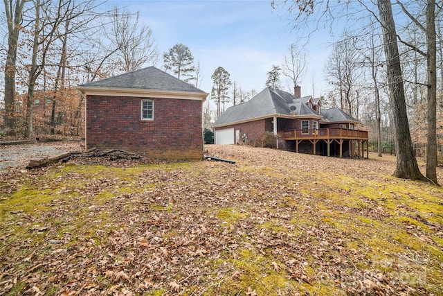 rear view of house with a garage and a deck