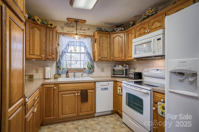 kitchen with decorative light fixtures, sink, white appliances, and backsplash