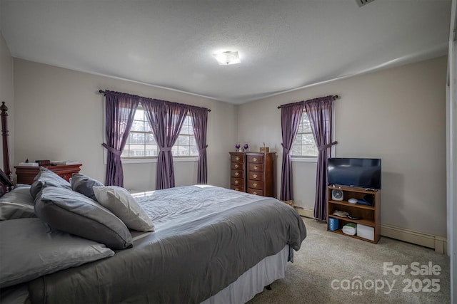 carpeted bedroom featuring a baseboard radiator, a textured ceiling, and multiple windows