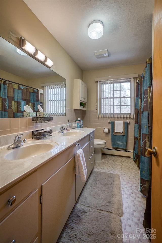 bathroom with baseboard heating, a textured ceiling, toilet, and vanity