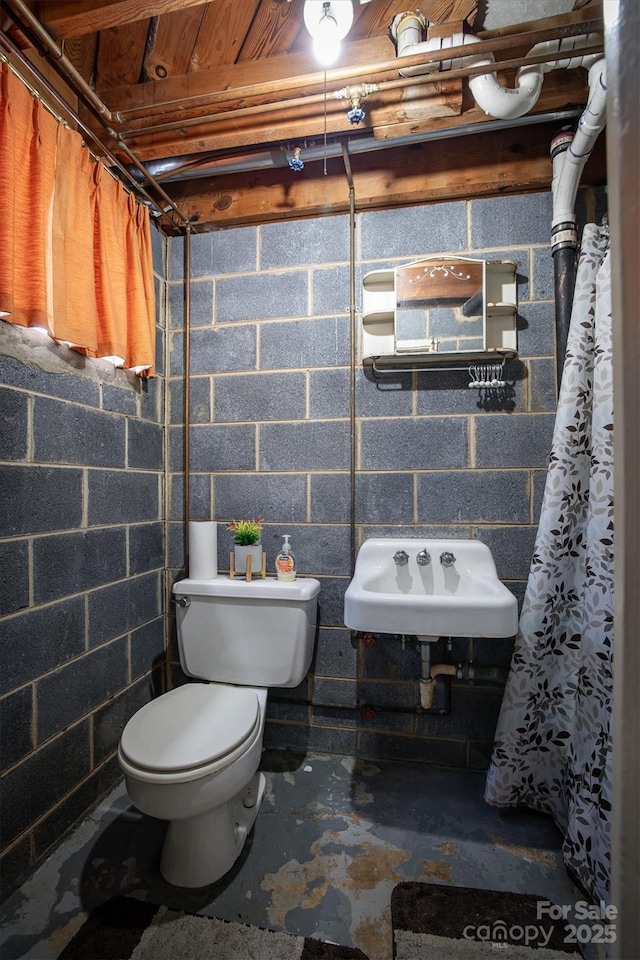 bathroom with sink, toilet, and concrete floors