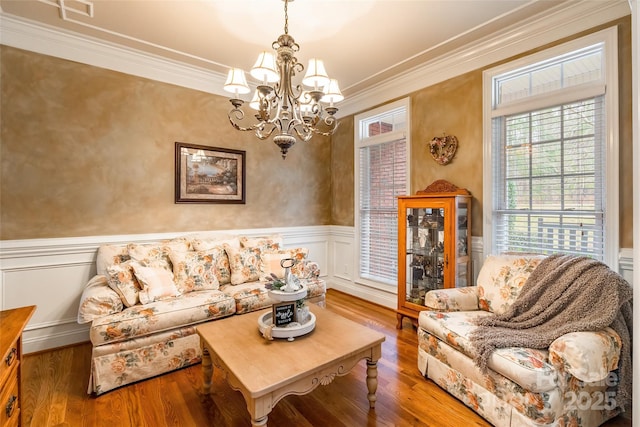 living room with an inviting chandelier, ornamental molding, and dark hardwood / wood-style flooring