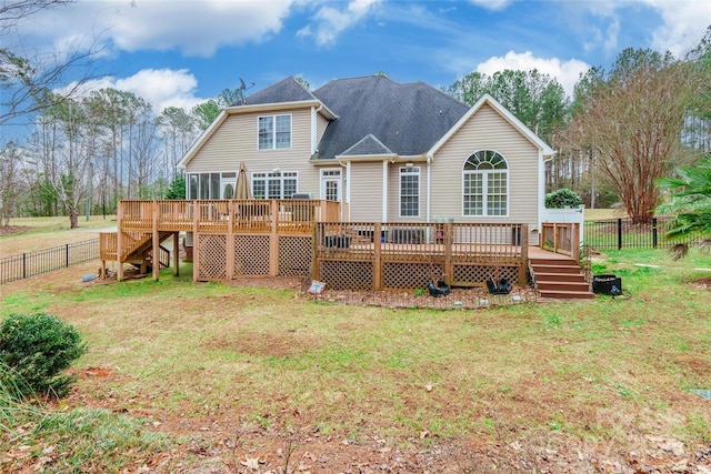 rear view of property featuring a wooden deck and a yard