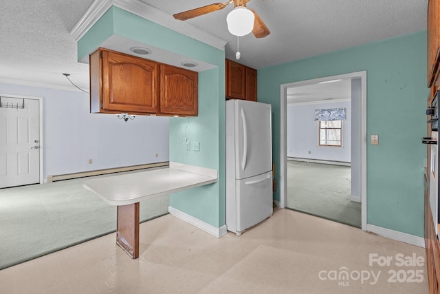 kitchen with white fridge, crown molding, a baseboard heating unit, and light colored carpet