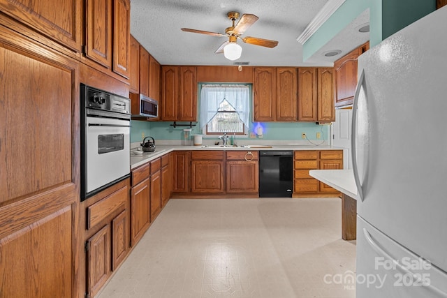 kitchen featuring a textured ceiling, white appliances, sink, and ceiling fan