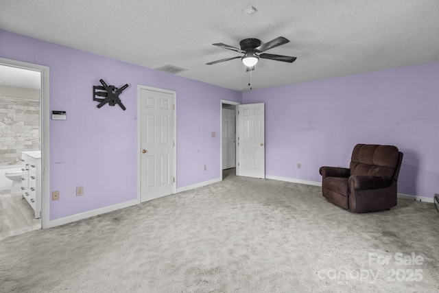 unfurnished room with a textured ceiling, light colored carpet, and ceiling fan