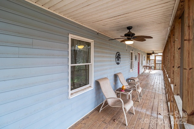 wooden terrace with ceiling fan and covered porch