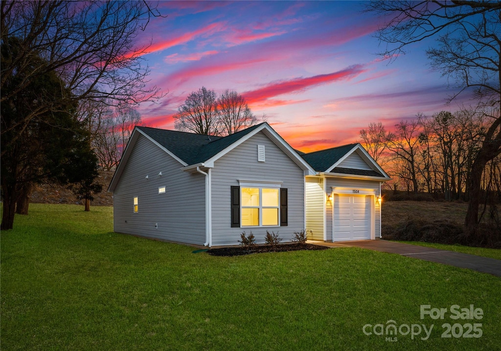 view of front of property with a garage and a lawn