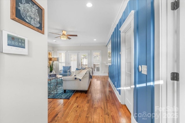 living room with ornamental molding, hardwood / wood-style floors, ceiling fan, and french doors