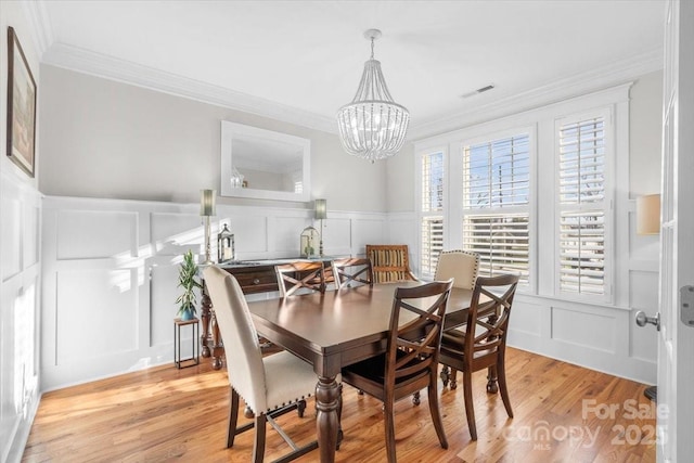 dining area featuring crown molding, plenty of natural light, and light hardwood / wood-style floors