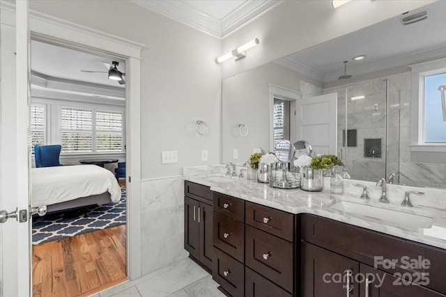 bathroom with vanity, a shower with shower door, ornamental molding, and tile walls