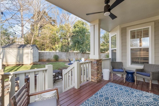 wooden deck featuring ceiling fan and a shed