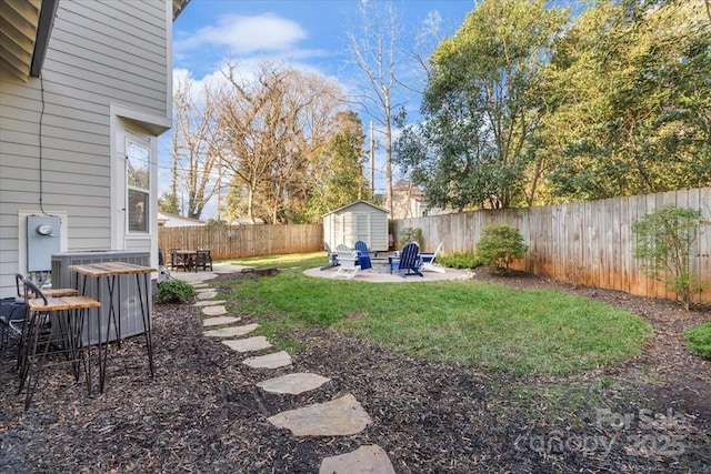 view of yard with a fire pit, a shed, and a patio area