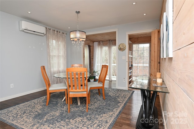 dining area with an AC wall unit, a notable chandelier, and dark hardwood / wood-style flooring