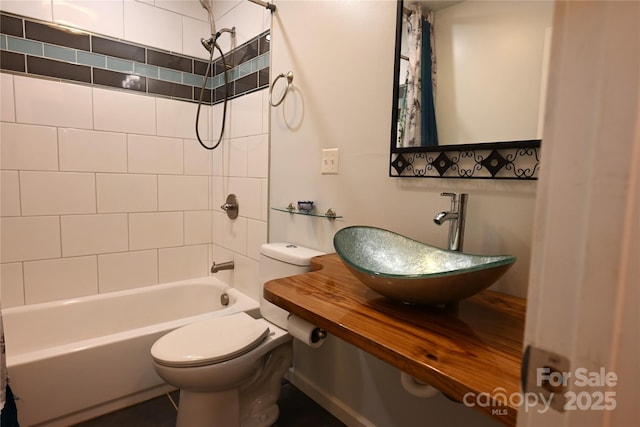 full bathroom featuring tiled shower / bath combo, sink, and toilet