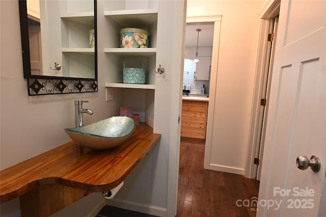 bathroom with tasteful backsplash, sink, and hardwood / wood-style floors